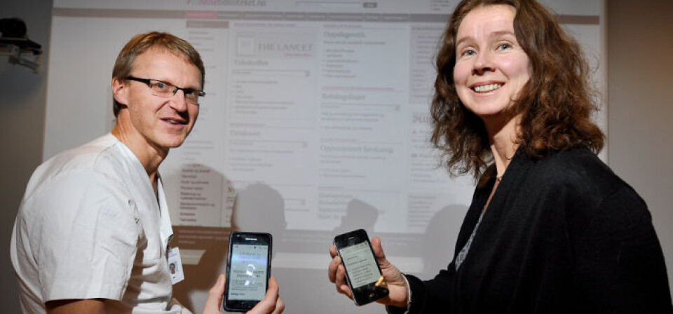 NYTT VERKTØY: Claus Klingenberg og Anne Hilde Røsvik fra Helsebiblioteket viser frem den nye appen for både akuttveileder og generell veileder i pediatri. Foto: UNN