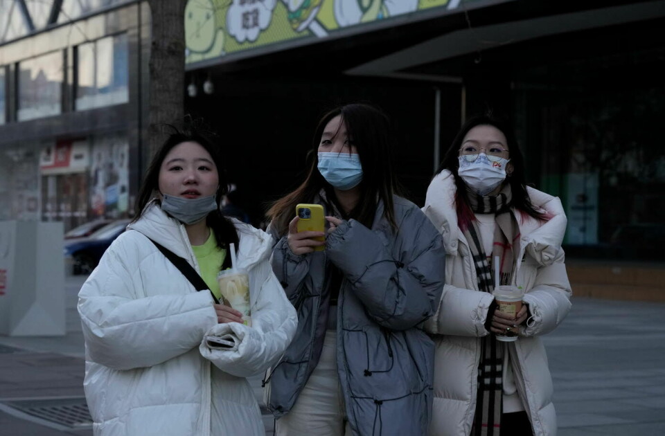 FULL AKTIVITET: Tre kvinner på handletur på et kjøpesenter i Beijing torsdag. Fjerningen av strenge koronarestriksjoner har ført til at kjøpesentre og restauranter igjen fylles opp av besøkende, mens det meldes om overfylte sykehus med koronasmittede. WHO ber Kina dele koronadata åpent og kontinuerlig med verdenssamfunnet.  Foto: Ng Han Guan / AP / NTB