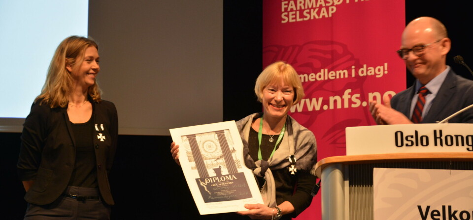 Kirsten Viktil mottar utmerkelsen Det giftige kors under farmasidagene. Til høyre for henne er styreleder i Norsk farmasøytisk Selskap, Håvard Selby Ebbestad, og til venstre er styremedlem Hedvig Nordeng. Foto: Vilde S. Baugstø