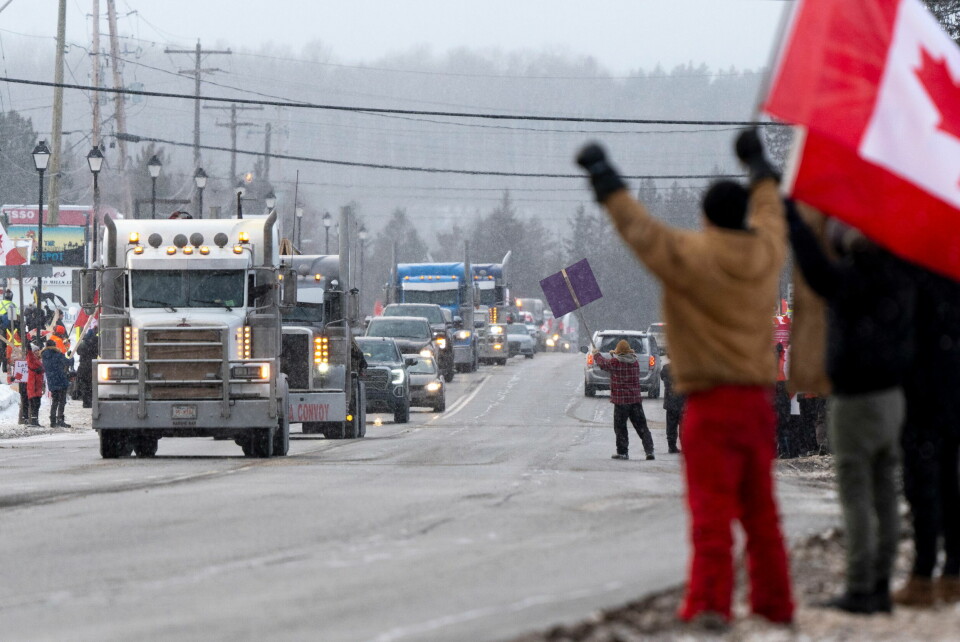 MOT VAKSINEPASS: Demonstranter mot vaksinepass heier på lastebilene som kjører gjennom Kakabeka Falls, Thunder Bay, Ontario. Foto: David jackson - AP NTB Foto: