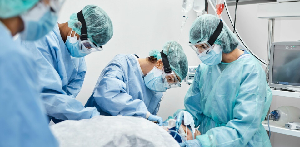 Helsepersonell tar seg av en covid-19-pasient på sykehus, ikledd smittevernsutstyr. Illustrasjonsfoto: Getty Images Foto: