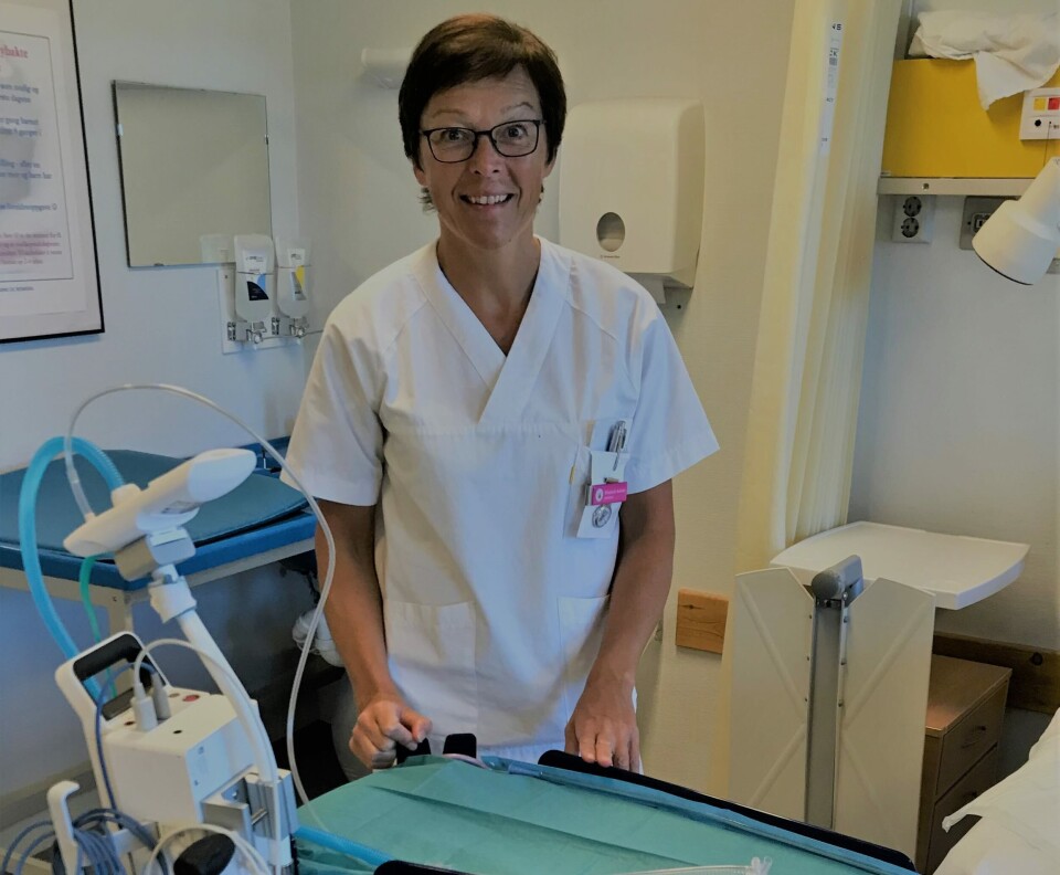 MOBILT UTSTYR: Fagjordmor Elisabeth Sæther peker på upraktiske innredninger av fødestudier og operasjonsstuer, hvor gjenopplivningsutstyr er plassert for langt unna. På fødeavdelingen i Ålesund har de mobilt gjenopplivningsutstyr for å sikre at barn som trenger pustestøtte ved fødselen, kan få dette uten å klippe navlesnoren. Foto: Ålesund Sykehus MOBILT UTSTYR: Fagjordmor Elisabeth Sæther peker på upraktiske innredninger av fødestudier og operasjonsstuer, hvor gjenopplivningsutstyr er plassert for langt unna. På fødeavdelingen i Ålesund har de mobilt gjenopplivningsutstyr for å sikre at barn som trenger pustestøtte ved fødselen, kan få dette uten å klippe navlesnoren. Foto: Ålesund Sykehus
