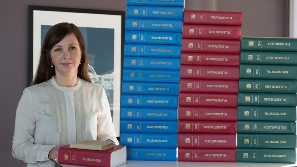 NÅ ER DET SLUTT: Felleskatalog-redaktør Bente By Jansen med tidligere utgivelser av Felleskatalogen i de karakteristiske blå, grønne og røde utgavene. Arkivfoto: Per Corneliussen Foto: