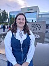 Person står foran Haukeland universitetssjukehus ved en moderne steinskulptur utendørs.