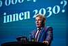 Bjørnar Skjæran står ved talerstolen på en scene med blå bakgrunn og teksten «innen 2030?»