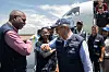 Tedros Adhanom Ghebreyesus hilser på personer ved Bunia lufthavn foran et fly.