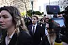Mark Zuckerberg i dress går gjennom en presseflokk i Los Angeles, med kameraer og journalister rundt seg.