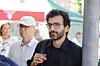 Kaveh Rashidi med briller og svart skjorte under Arendalsuka, med mennesker og fargerike telt i bakgrunnen.