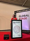 Taler bak en talerstol på en konferansescene med ESC Congress 2026-grafikk.